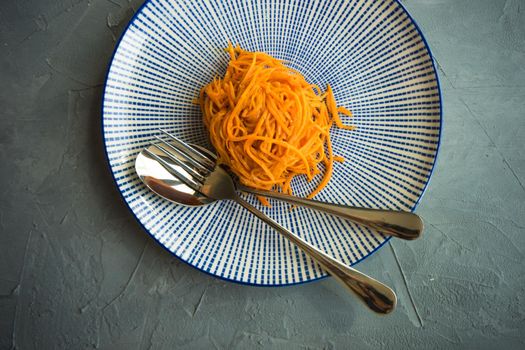 Organic spicy carrot salad on rustic table with copyspace as an organic food concept