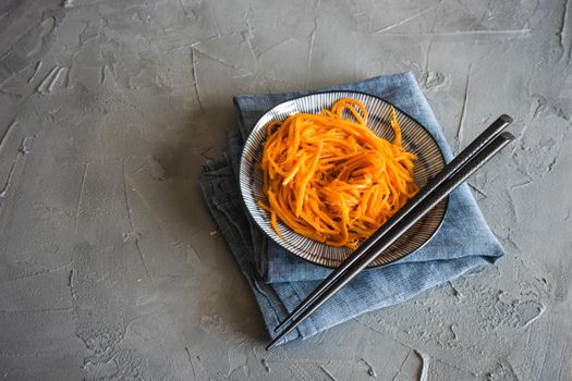 Organic spicy carrot salad on rustic table with copyspace as an organic food concept
