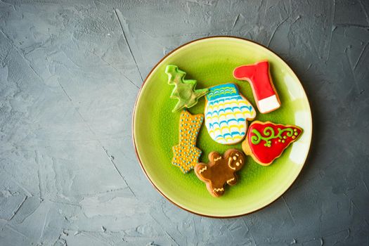 Festive gingerbread cookies for Christmas holiday celebration on ceramic plate on concrete background with copyspace