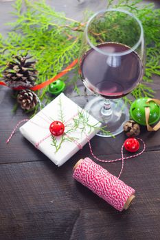 Christmas concept with glas of red wine and gifts on dark wooden table with copyspace