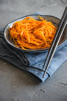 Organic spicy carrot salad on rustic table with copyspace as an organic food concept