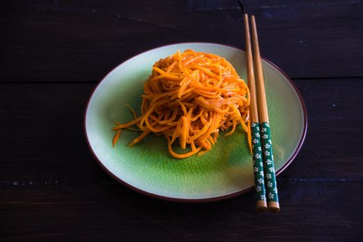 Organic spicy carrot salad on rustic table with copyspace as an organic food concept