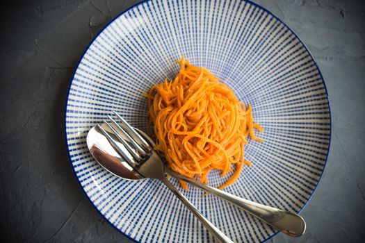 Organic spicy carrot salad on rustic table with copyspace as an organic food concept
