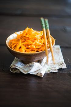 Organic spicy carrot salad on rustic table with copyspace as an organic food concept