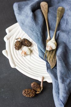 Autumnal table setting with acorns and rustic plates on dark wooden table