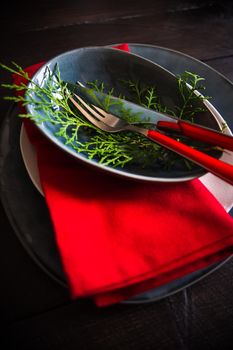 Festive table setting for Christmas dinner on dark rustic table with copyspace