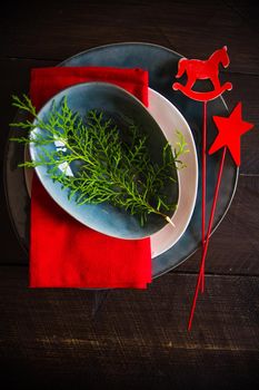 Festive table setting for Christmas dinner on dark rustic table with copyspace