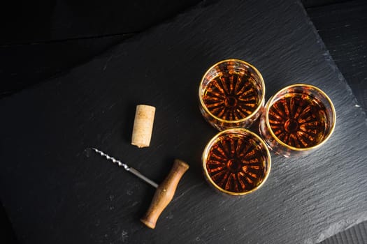 Glacc of cognac with ice on rustic background with copyspace