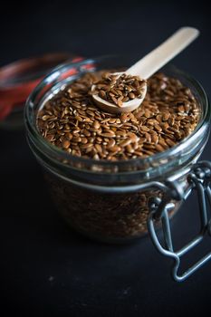 Organic food concept with flax seeds on dark wooden background