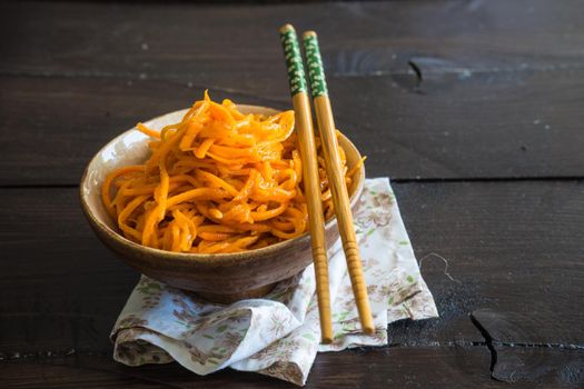Organic spicy carrot salad on rustic table with copyspace as an organic food concept