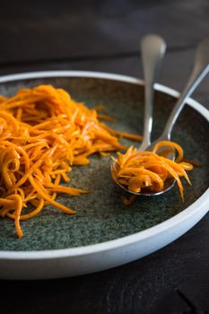 Organic spicy carrot salad on rustic table with copyspace as an organic food concept