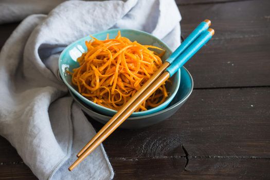 Organic spicy carrot salad on rustic table with copyspace as an organic food concept