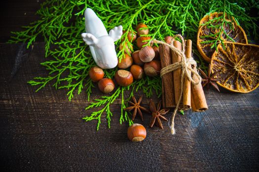 Christmas spices lika an anise star, cinnamon sticks and nuts on dark wooden table