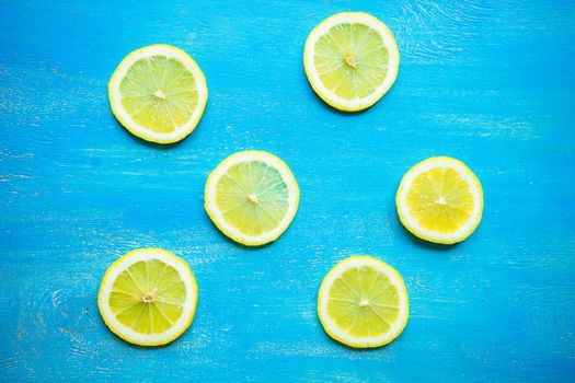 Summer fruit concept with slices of ripe yellow lemon on rustic wooden background with copyspace