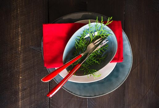 Festive table setting for Christmas dinner on dark rustic table with copyspace