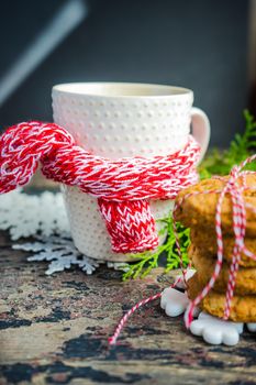 Cup of tea with lemon and cinnamon spice and Christmas decoration on rustic wooden table