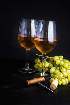 Organic ripe grape and vintage corkscrew on rustic background as a wine concept