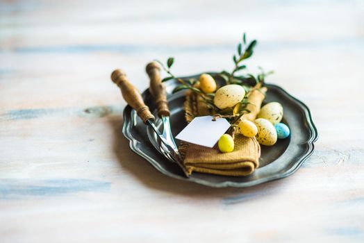 Table setting for Easter dinner with eggs on rustic wooden table