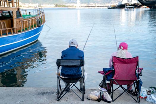 Turkey, Alanya - November 9, 2020: Elderly couple is fishing in the port of Alanya. Pleasant leisure and lifestyle of pensioners. 