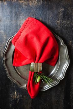 Rustic table setting with vintage tableware  and branch of Christmas tree  on dark wooden table with copyspace