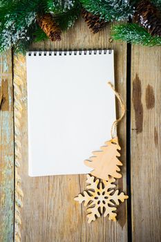 Christmas festive concept with notepad and christmas tree branch and decoration on old wooden table with copyspace