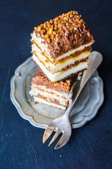 Vanilla and chocolate biscuit cake on rustic wooden table