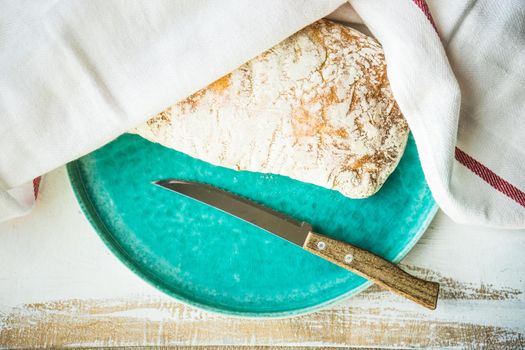 Fresh baked italian bread - ciabatta  on rustic table with napkin