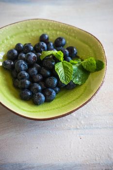 Ripe organic bilberries on dark wooden table with copyspace as a organic food concept