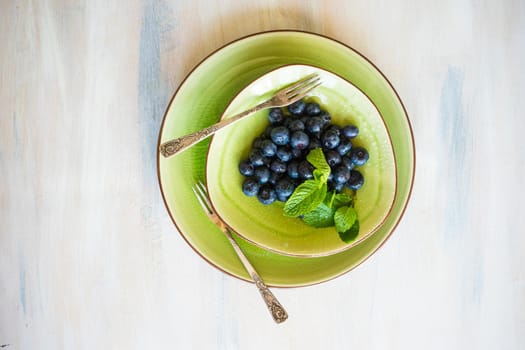 Ripe organic bilberries on dark wooden table with copyspace as a organic food concept