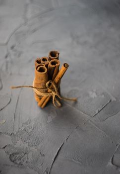 Cinnamon sticks on grey concrete background with copyspace