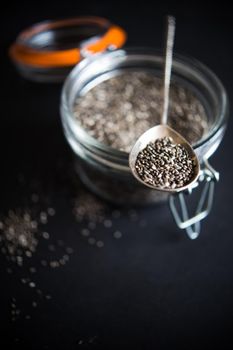 Organic chia seeds on dark wooden table with copyspace