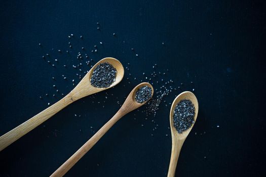 Organic chia seeds on dark wooden table with copyspace