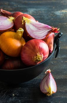 Organic food concept with red onion on dark cutting board with copyspace