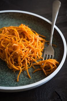 Organic spicy carrot salad on rustic table with copyspace as an organic food concept