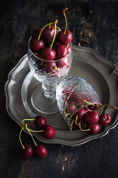 Organic food concept ripe red sweet cherries on dark wooden table