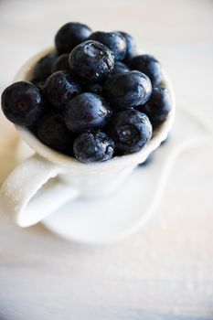 Ripe organic bilberries on dark wooden table with copyspace as a organic food concept