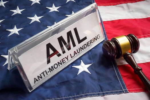 Plate with Anti Money Laundering AML, a gavel and flag.