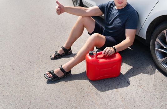 The driver wants to refuel in an empty car tank, an empty red canister on the side of the road. Stops on the road. Fuel problem, force majeure