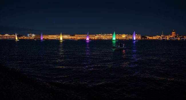 Russia, St. Petersburg, 07 August 2022: A few sailboats with sails illuminated in the tricolor of Russia go in the city center at the celebration of the opening of the sailing week, sightseeing . High quality photo