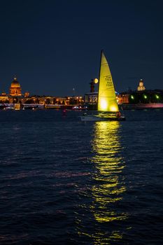Russia, St. Petersburg, 07 August 2022: A few sailboats with sails illuminated in the tricolor of Russia go in the city center at the celebration of the opening of the sailing week, sightseeing . High quality photo