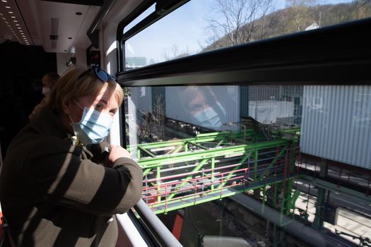 woman looking out the window of Wuppertaler Schwebebahn, Wuppertal suspension railway, unique public transport in Germany, city tram. High quality photo