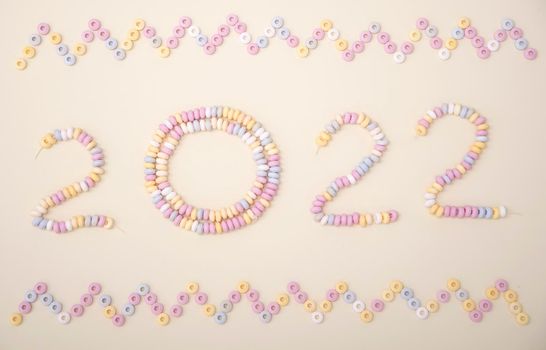 figures of the year 2022 lined with pastel colors candies lettering High quality photo