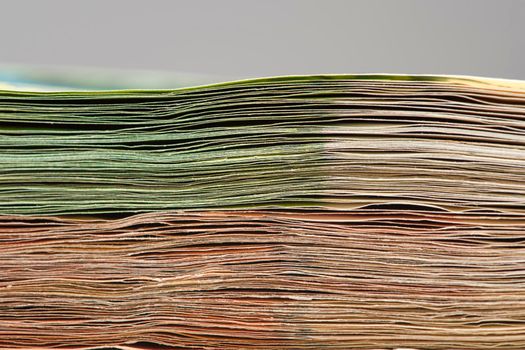 Close-up of a stack of paper bills, side view. Euro banknotes stacked on top of each other. Big pile of money