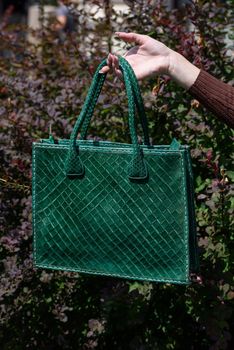 close-up photo of green leather bag. Outdoors