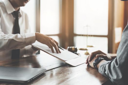 Reading the contract and signing the real estate purchase, the buyer is reading the important documents before entering into a building buy agreement with the agent.