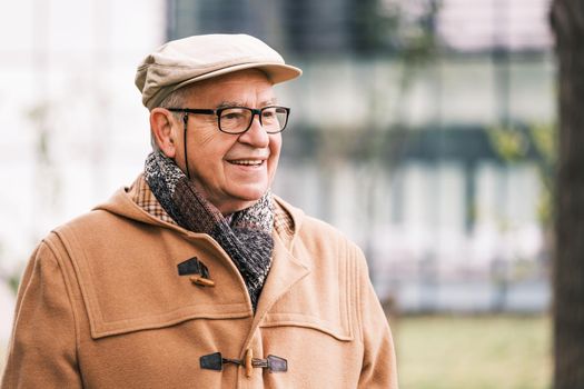 Outdoor portrait of cheerful senior man in winter coat.