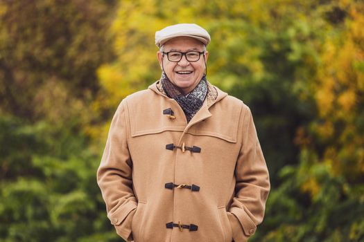 Outdoor portrait of cheerful senior man in winter coat.