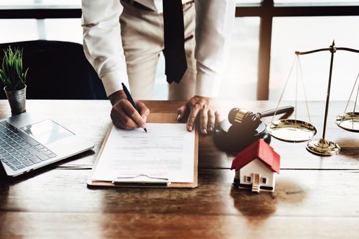 Reading the contract and signing the real estate purchase, the buyer is reading the important documents before entering into a building buy agreement with the agent.