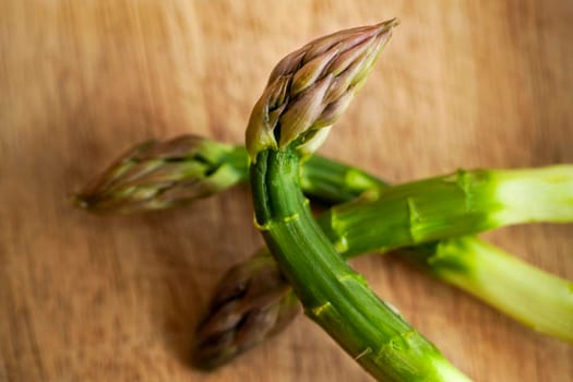 Close up of green asparagus on a wooden table in a kitchen