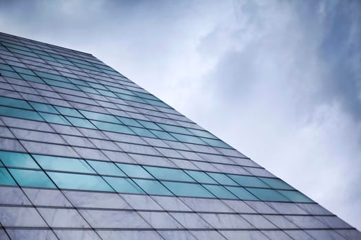 Glass wall of a building facade and cloudy sky